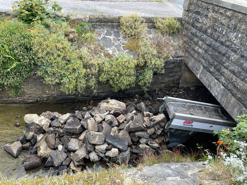 removing large pile of rocks which were blocking stream under bridge